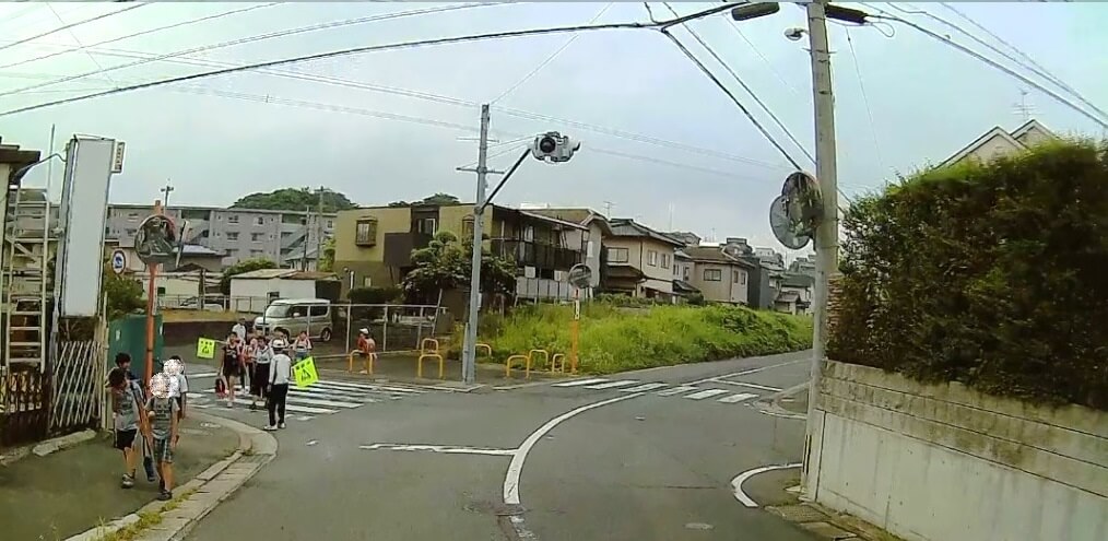 大辻町点滅信号の横断歩道を渡る子どもたちの写真
