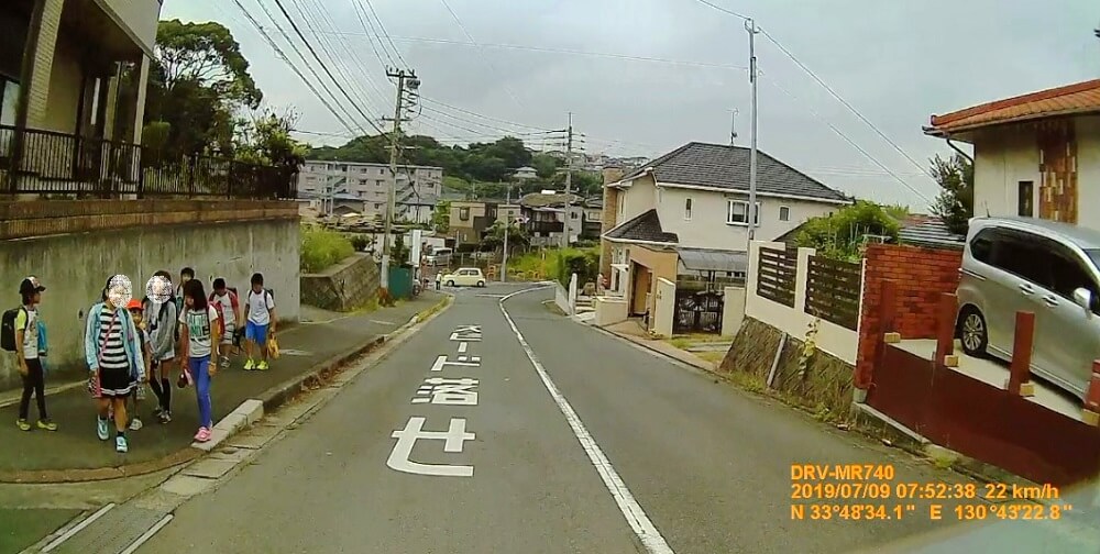 大辻の点滅信号からの坂道を登校する子どもたちの写真