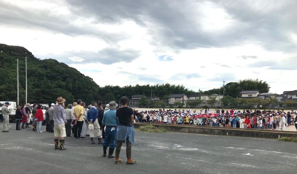 地域の方の前に児童・保護者が集合している写真