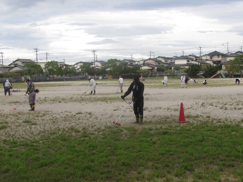 地域の方が草刈り機で刈っているの写真
