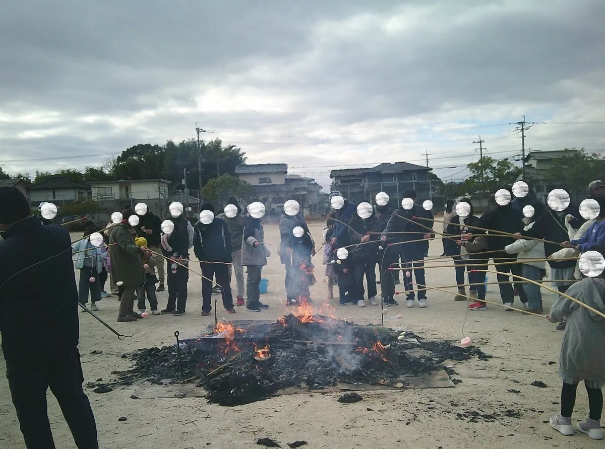 残り火の周りで餅を焼いている様子
